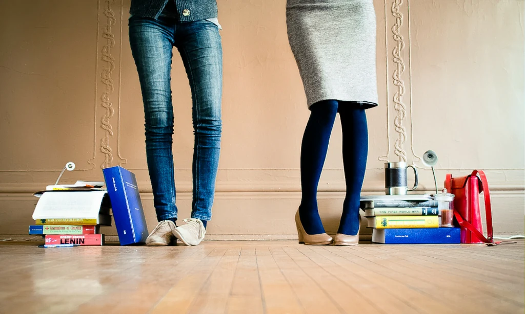 Stacks of academic books on a wooden floor