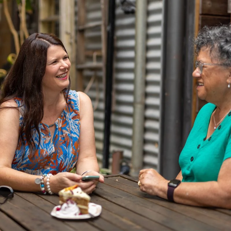 Carolyn laughing in outdoor coaching conversation