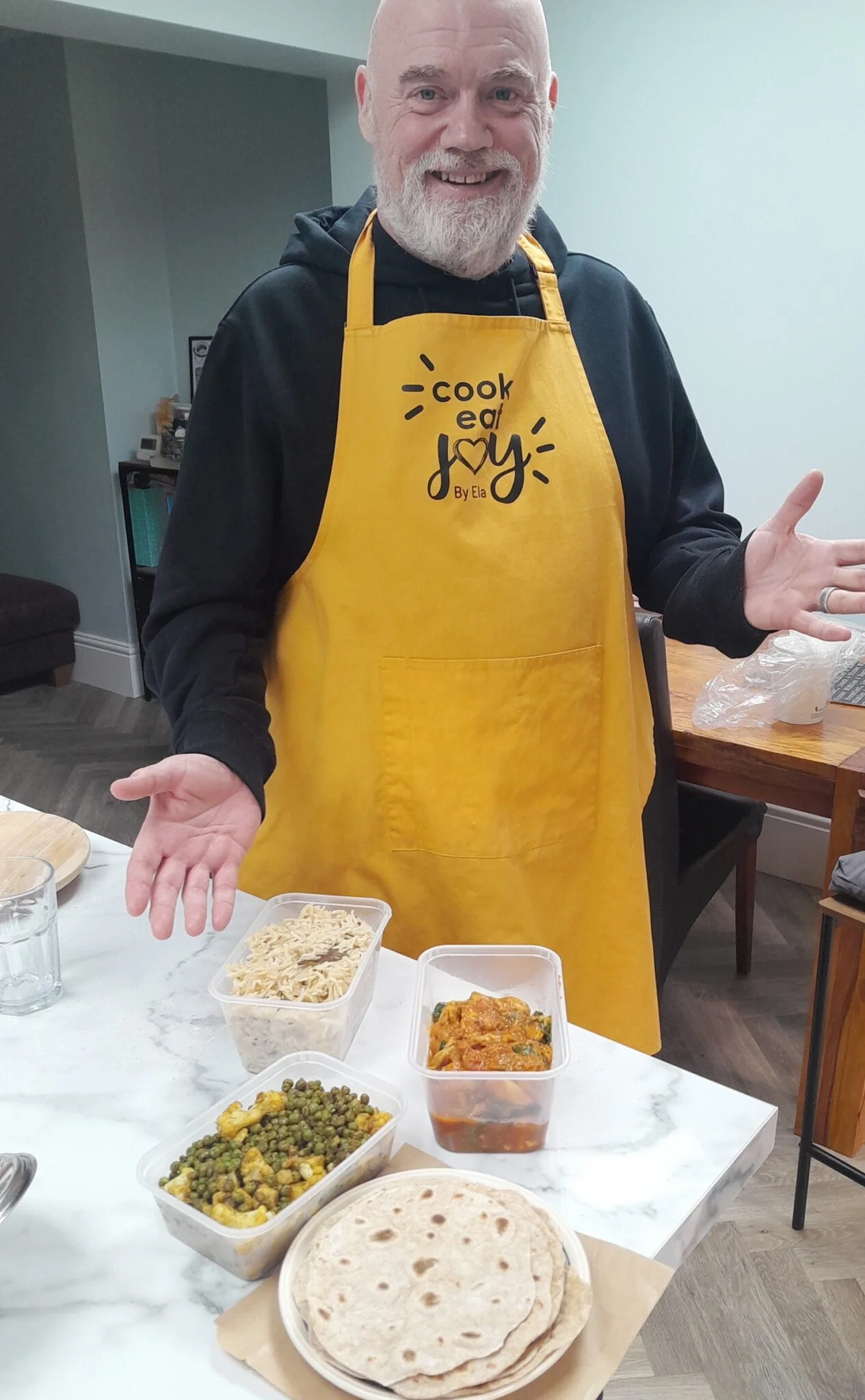 Home cooking workshop with attendee showing prepared Indian feast