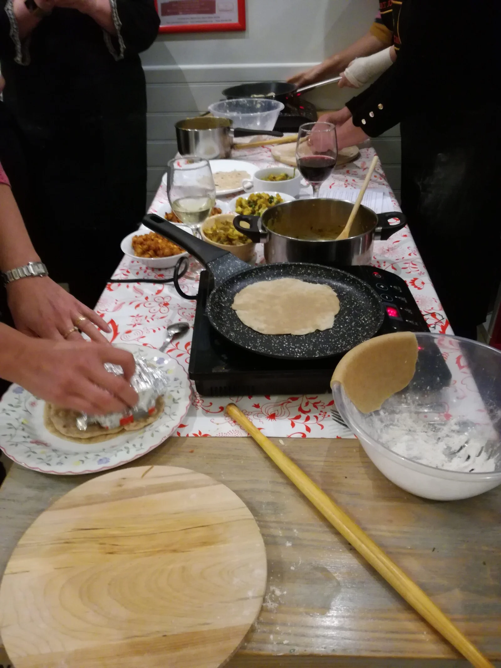 Rolling fresh chapatis and preparing Indian food at the class table